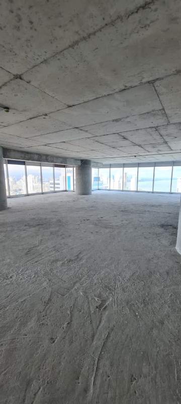 Large grey-box unfinished corporate office with floor-to-ceiling windows ocean and city views Punta Pacifica Oceania Panama