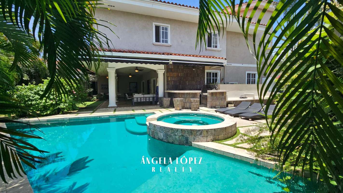 Spacious entrance hall featuring curved staircase with wrought iron railing in Costa del Este luxury house