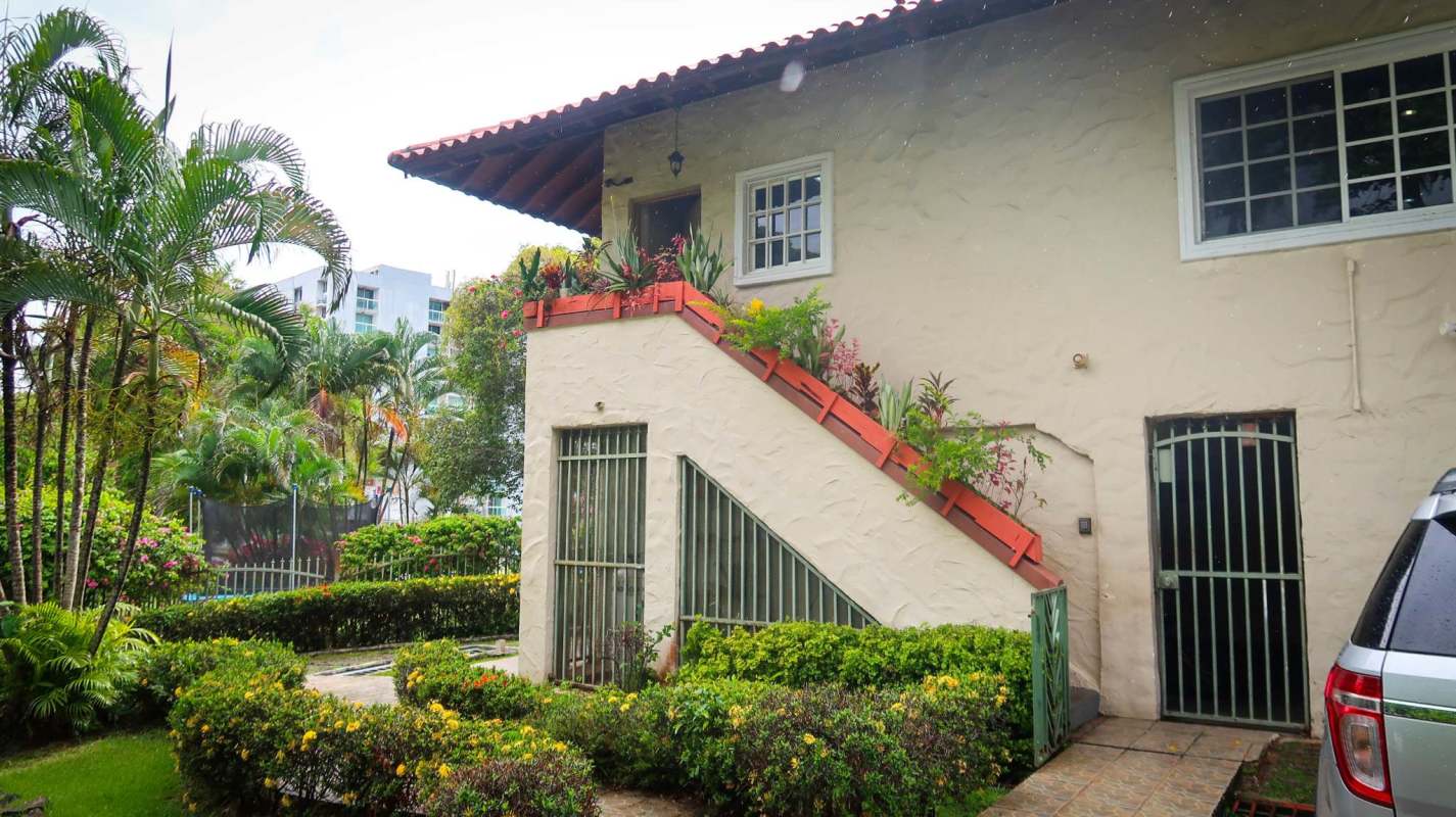 Exterior facade with tile roof, beige stucco, staircase with planters and lush gardens Albrook Panama