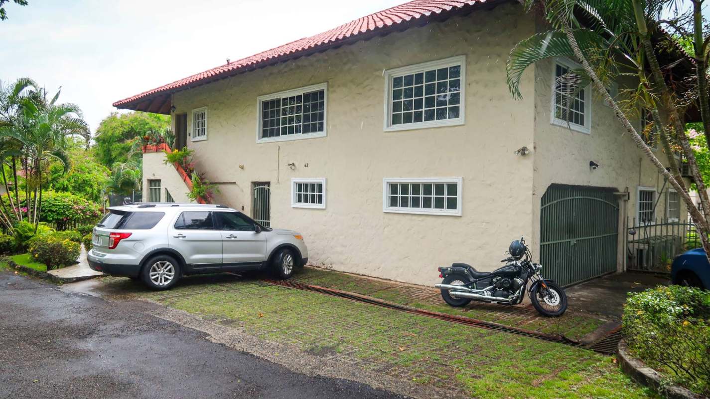 View of large two-story multifamily house with tropical gardens and driveway Albrook Panama