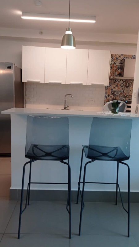 Modern kitchen in PH Altamira Residences with white cabinets, mosaic tile backsplash, stainless appliances in Panama City