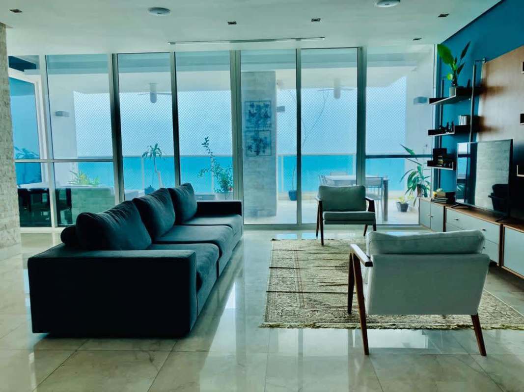 Spacious living area with marble floors, ocean views via glass walls at PH Vitri Tower penthouse Panama