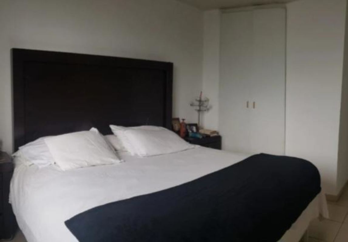 Bedroom with dark headboard, closet, minimalist design PH RIM Tower Panama