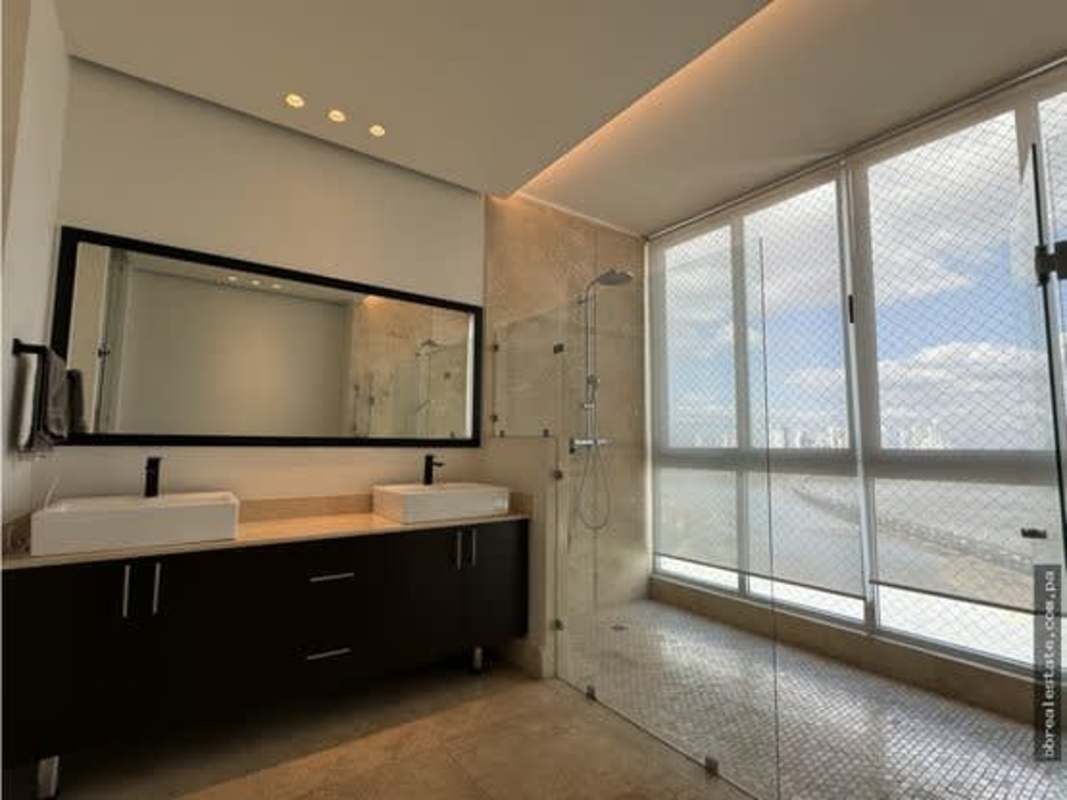 Double sink modern bathroom with large ocean view window at PH Ocean Sky Panama City