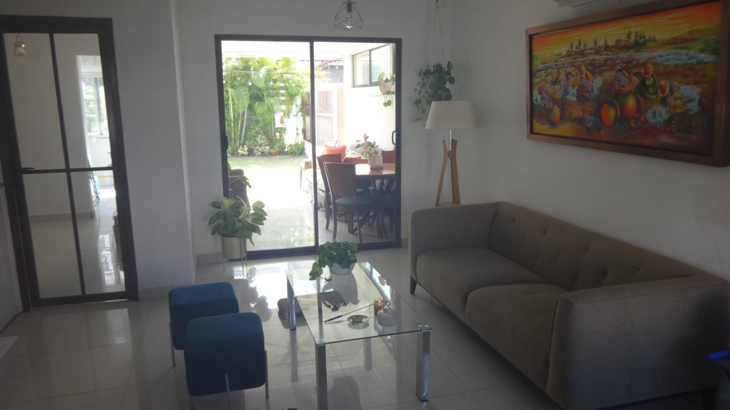 Modern living room with glass doors, plants, gray sofa, Villa Zaita Panama
