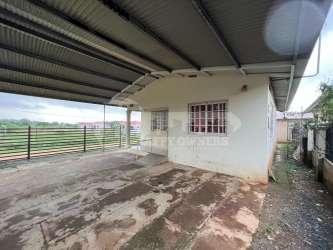 Compact bathroom with toilet sink and shower curtain at house for sale in Chitre Panama