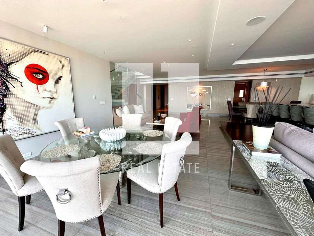 Dining area with modern decor and glass staircase in PH Ocean Sky Coco del Mar