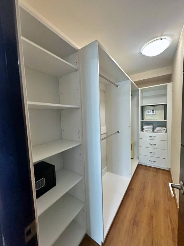 Spacious master bedroom with wood flooring, city view window in Bayfront Loft Panama City