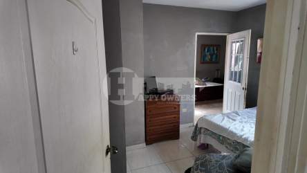 Bedroom with white walls, tile floors, window in Marbella Chitré Panama house