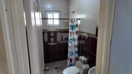 Small tiled bathroom with shower, bidet and window in Marbella Chitré house