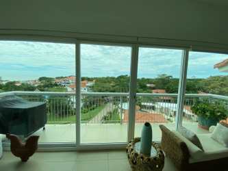 Bright bedroom with window, wooden bed, teal curtains at Punta Barco Village Panama