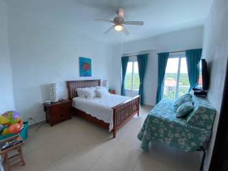 Bright bedroom with window, teal accents and natural light in Punta Barco Village Panama apartment