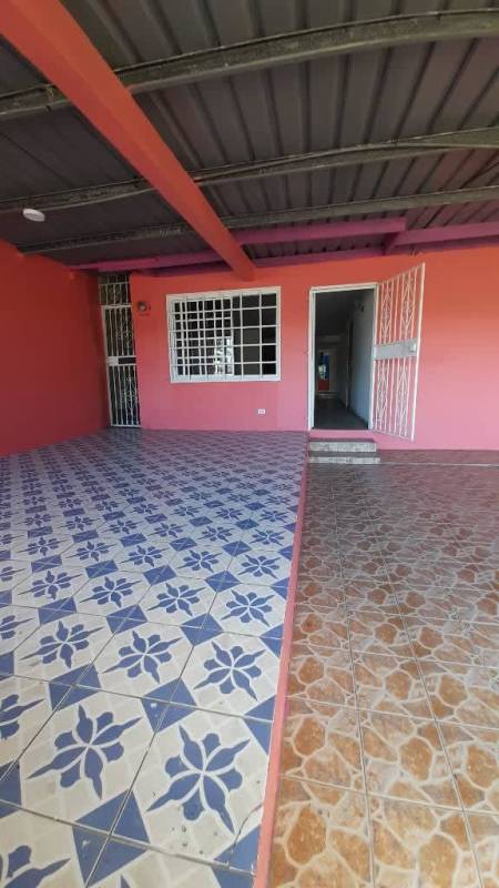 Tile floor hallway connected to kitchen with white cabinets Panama City house