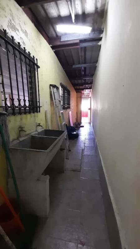 Covered carport space at front of pink home with driveway gate Nuevo Hipódromo Panama