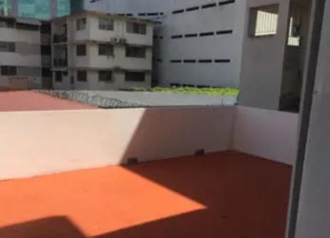 Outdoor terrace area enclosed with walls, adjacent buildings visible, city center view PH Montserrat Obarrio