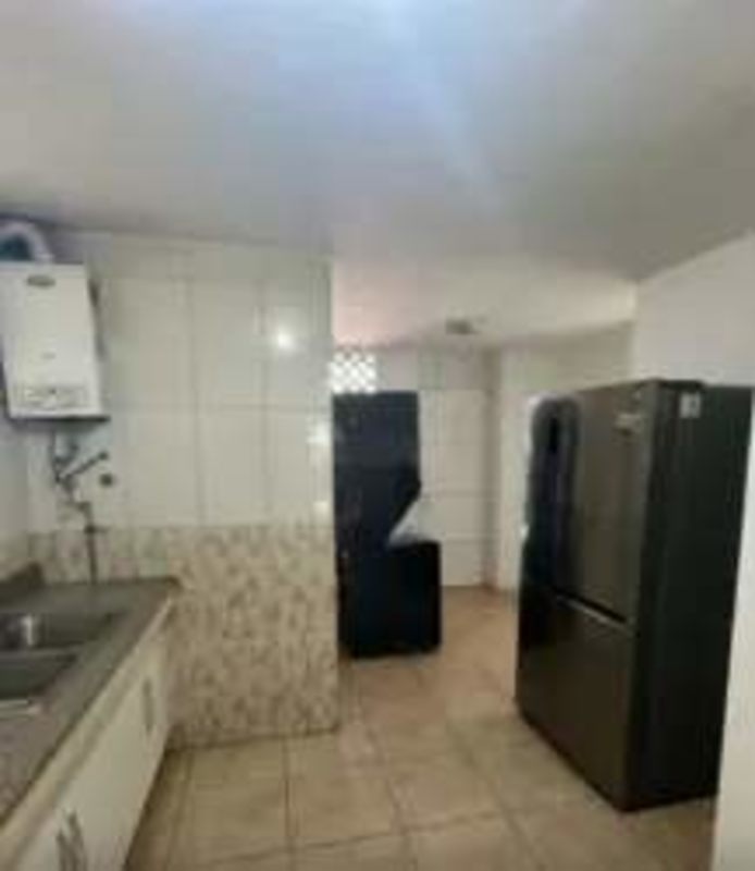 Simple kitchen with double sink, granite counters, wall tiles, water heater at PH Montserrat Obarrio