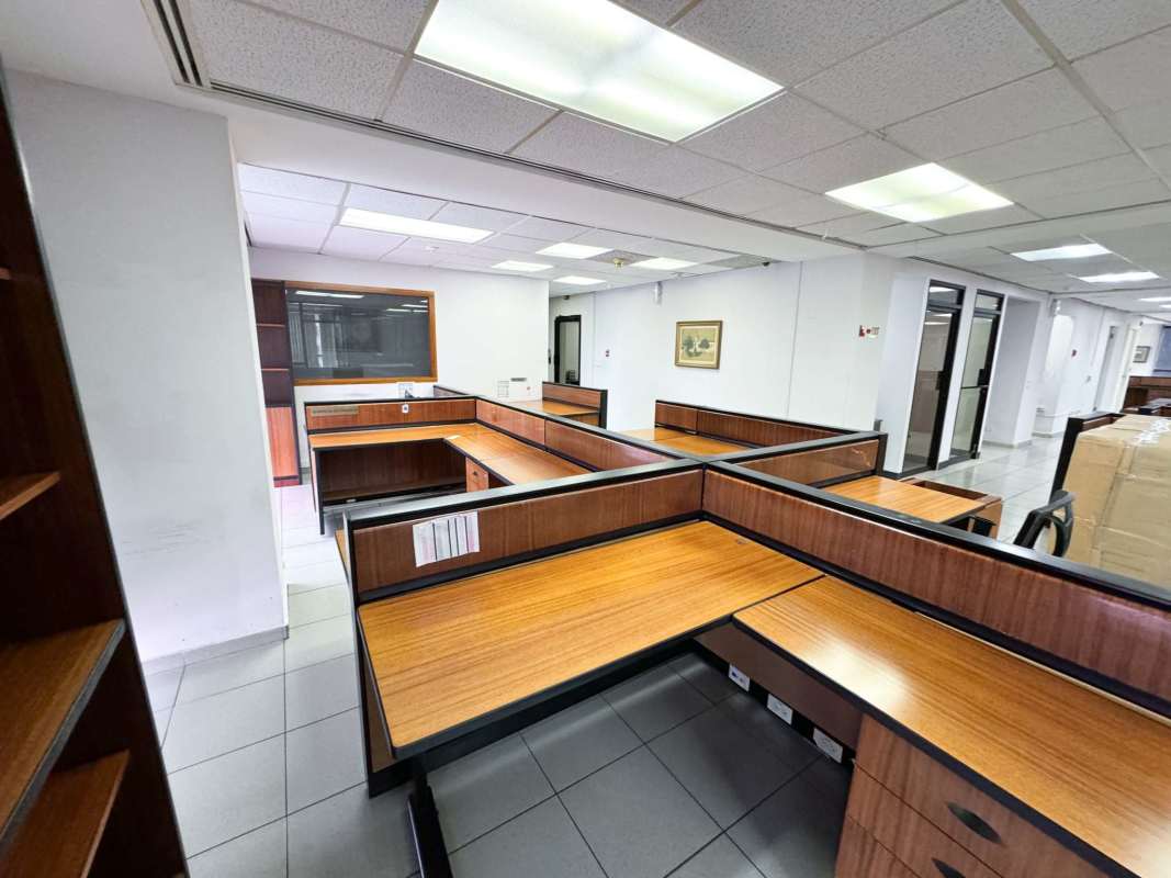 Corporate workspace area with several cubicle setups, tiled floor, recessed lights PH Humbold