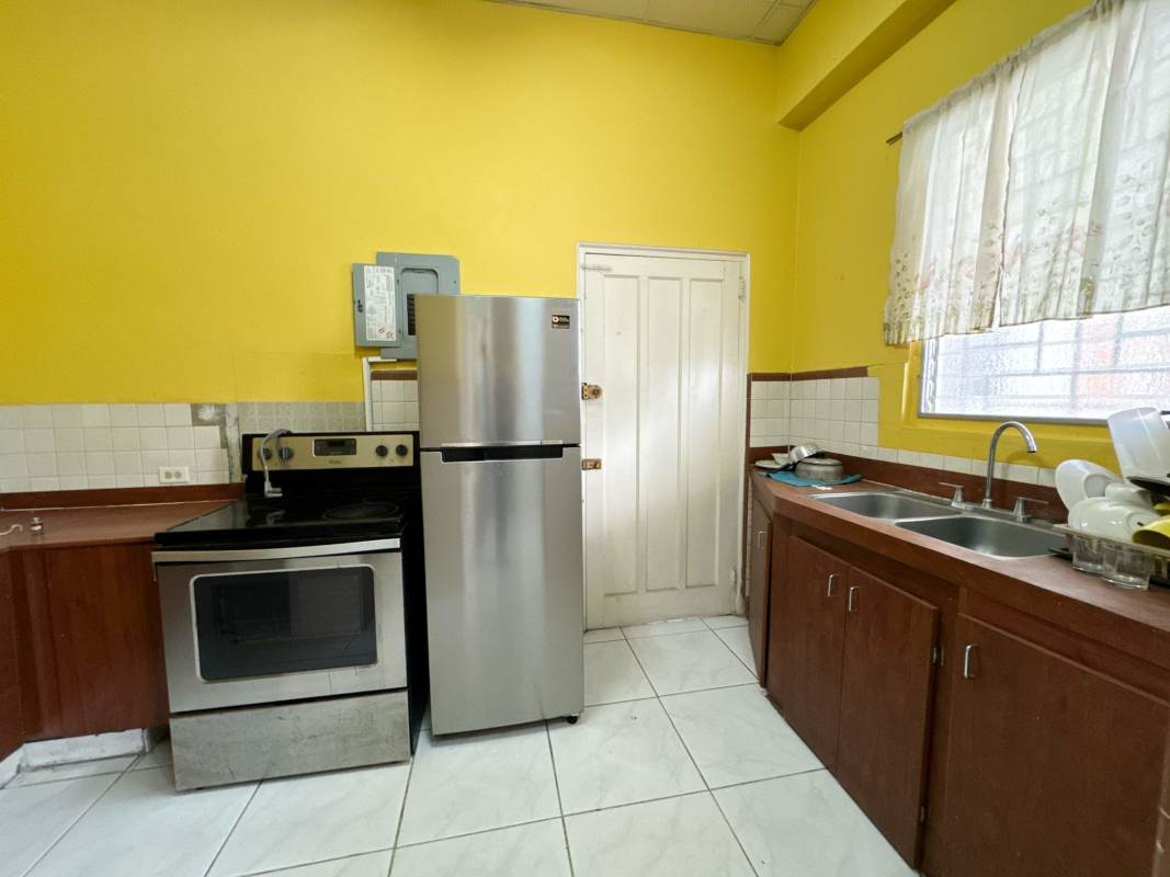 Dining and living space with glass table, tiled floor, pendant light, minimalist furnishing in PH America Panama City