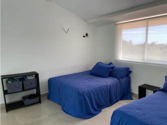 Spacious loft bedroom with two beds, windows, minimalist decor in Punta Chame Panama