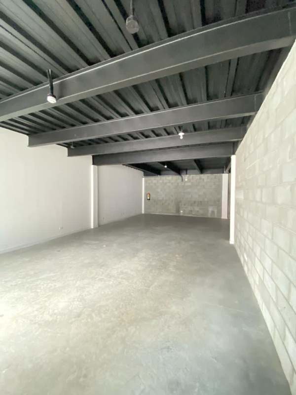 Empty unfinished commercial interior with concrete floor and exposed metal ceiling Rio Abajo Plaza