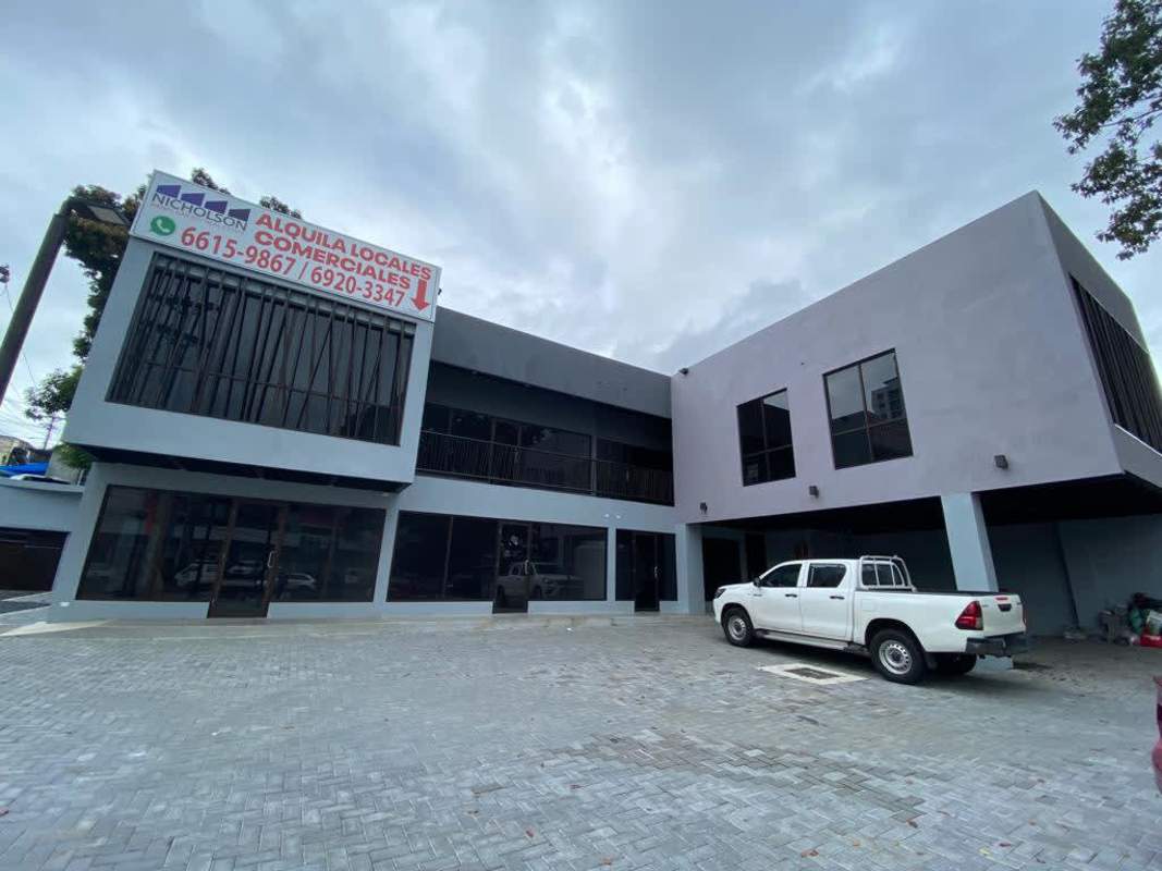 Contemporary two-story commercial building with large windows, parking and signage on Vía España Panama City