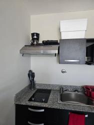 Compact minimalist kitchenette with appliances and breakfast bar in PH Ibiza Coronado apartment Panama