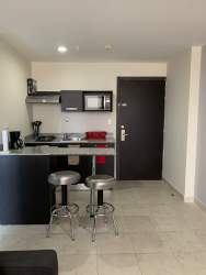 Small kitchen area with granite countertop, appliances in PH Ibiza Coronado suite Panama