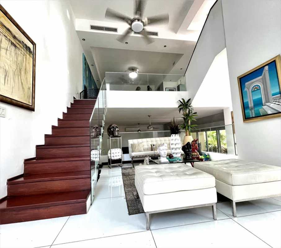 Elegant dining with glass table, large art and modern chandelier at Altos del Golf Panama