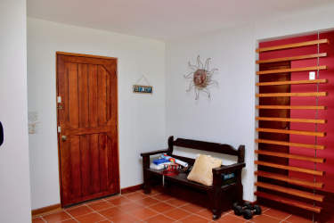 Rustic entry with tile flooring, wooden bench and decor at Coronado home