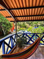 Colorful hammock on rustic porch with lush mountain garden views Altos del María Panama rental