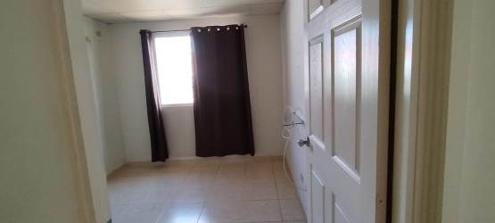 Bedroom interior with white walls, dark curtains, tile floor in La Chorrera Panama