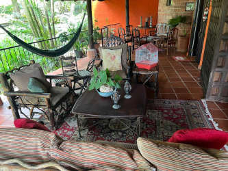Living room with exposed beams, terracotta tile floor, multiple windows and comfortable seating in Las Lajas Sora