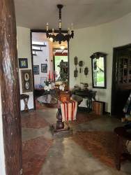 Curved outdoor pool surrounded by brick patio, lounge chairs, with mountain scenery in Sora Panama