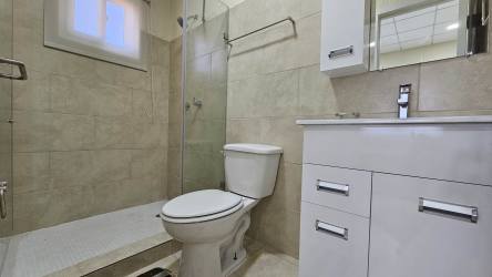 Clean minimalist kitchen with double sink, tiled backsplash, ceramic floors in Panama house