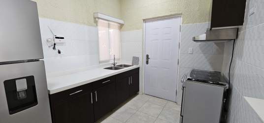 Modern bathroom featuring vanity, glass shower, beige tiles in La Chorrera house Panama