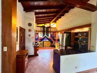 Rustic kitchen with wood cabinetry, tiled counters and exposed beams in Valle de Antón Panama