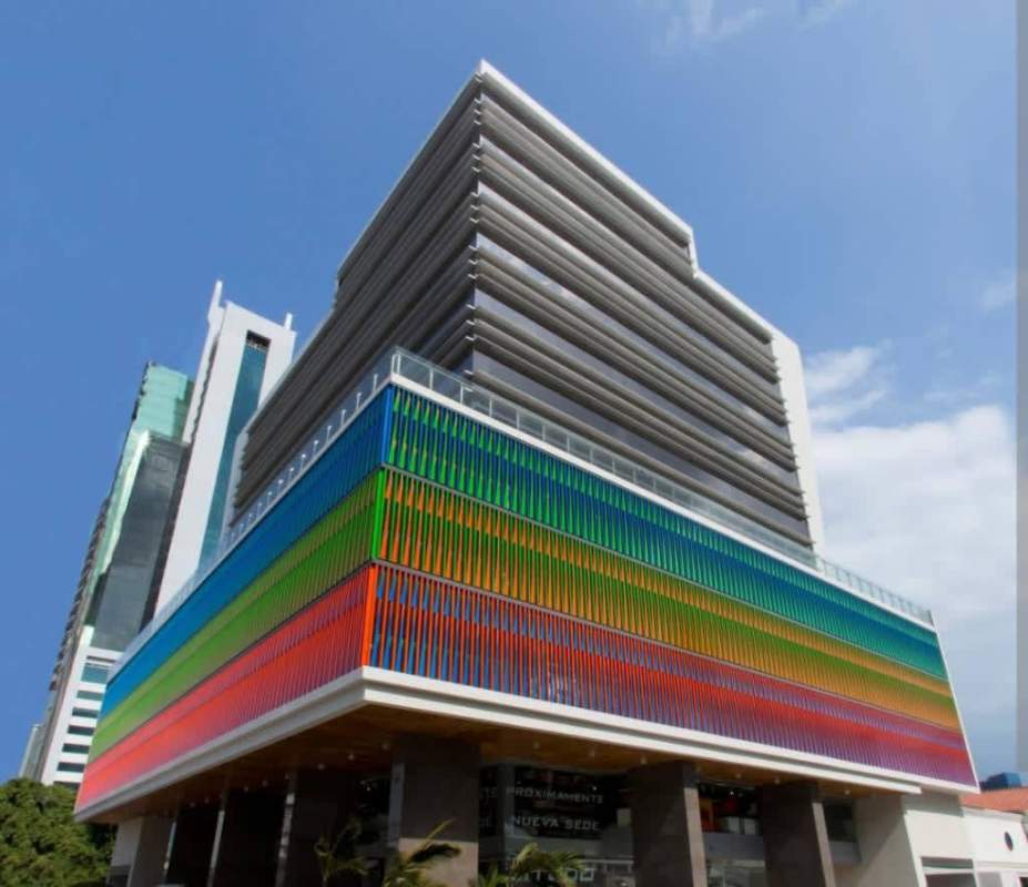 Two-level showroom interior with wooden stairs, glass railings, displayed furniture at Kenex Plaza Obarrio