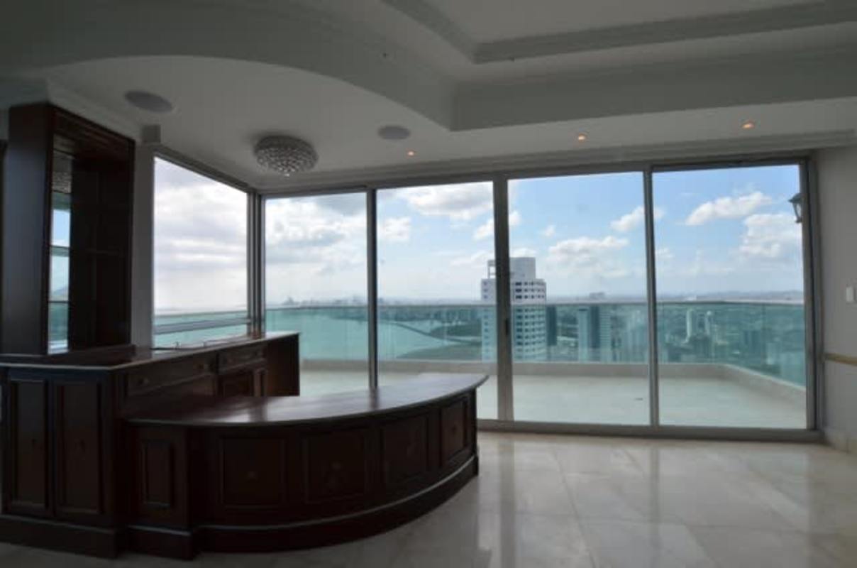 Living room with large panoramic windows overlooking ocean and skyline PH Ocean Two Penthouse