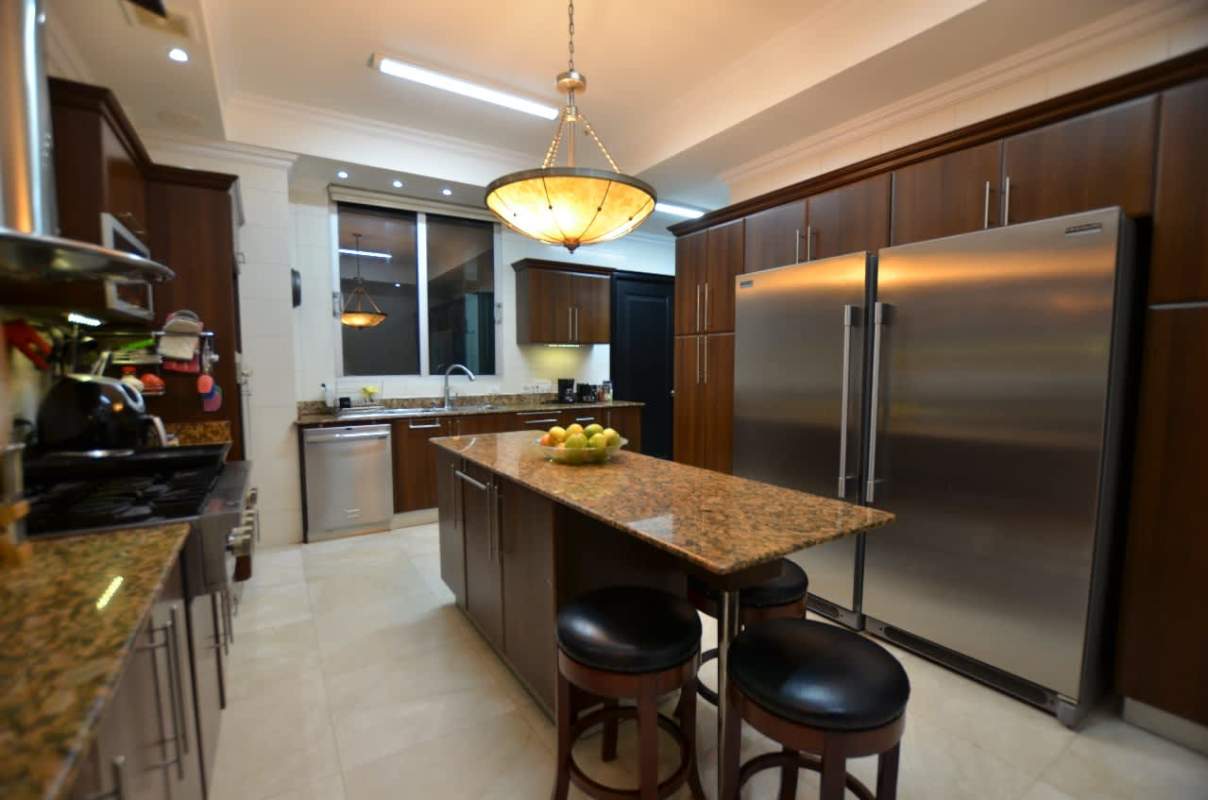 Kitchen with granite island dark wood cabinets stainless appliances PH Ocean Two penthouse