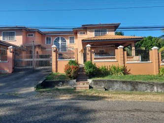 Two-story Mediterranean peach tone house with arched windows and gated entrance in Guadalupe La Chorrera