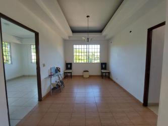 Living room area with large window tiled floor and glass console table in Guadalupe La Chorrera