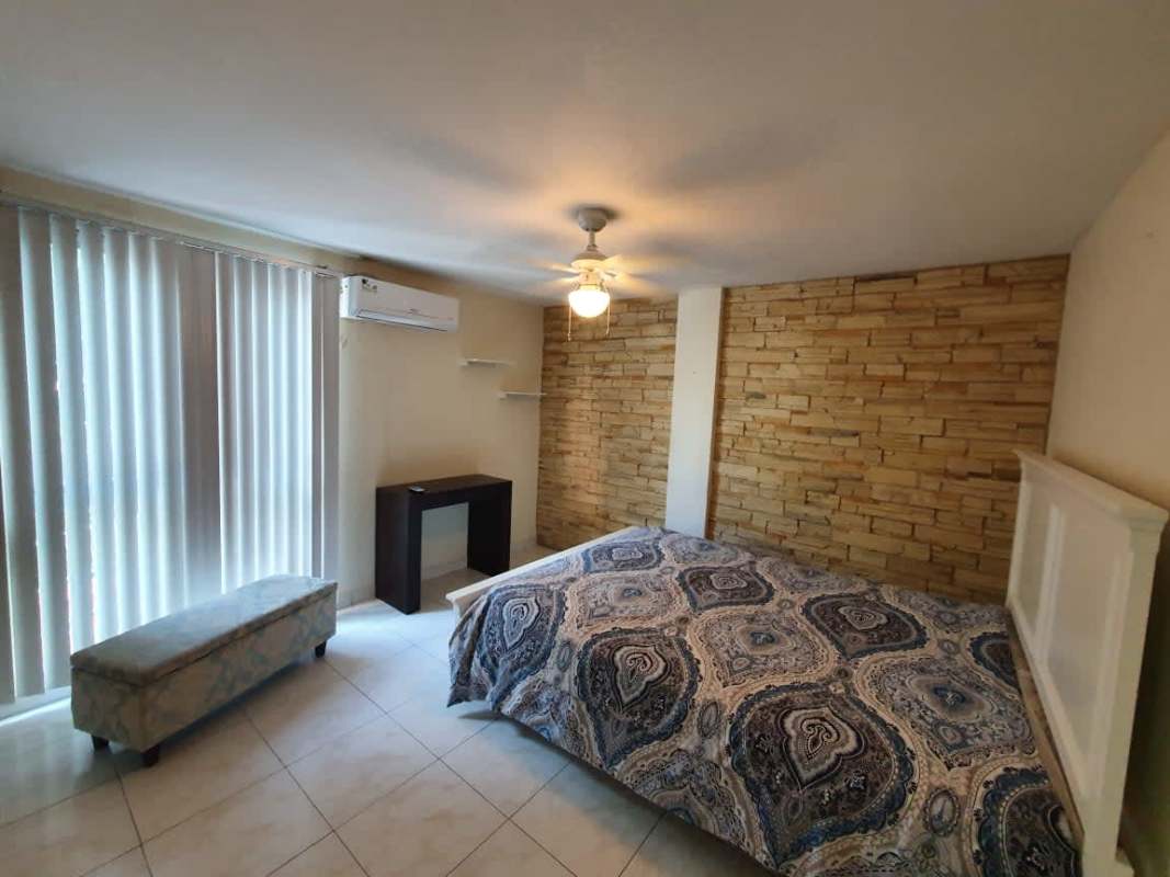Bedroom with stone accent wall, AC unit, fan, garden views in PH Clayton Park Panama
