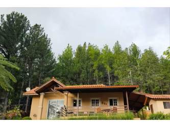 Rustic cottage with terracotta roof and porch in forest setting Altos del María Panama
