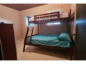 Bedroom with bunk beds, tiled floor, wood ceilings, natural light Altos del María Panama