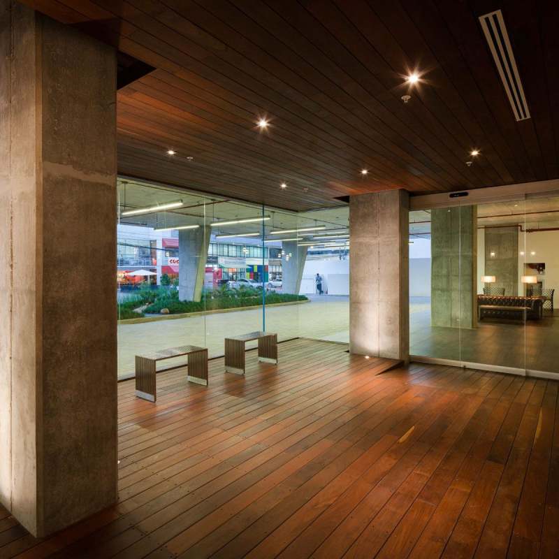 Modern lobby with glass walls, concrete columns, wood accents and minimalist decor in Midtown tower Panama City