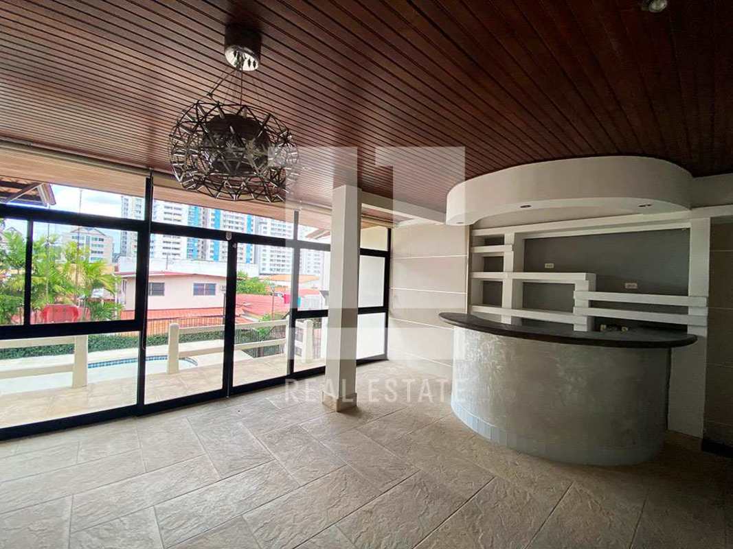 Elegant lounge with curved bar counter, large windows, overlooking pool and Panama City skyline