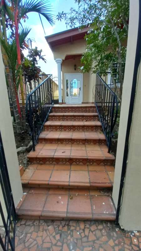 Decorative tile steps with wrought iron railing at front porch Brisas del Golf
