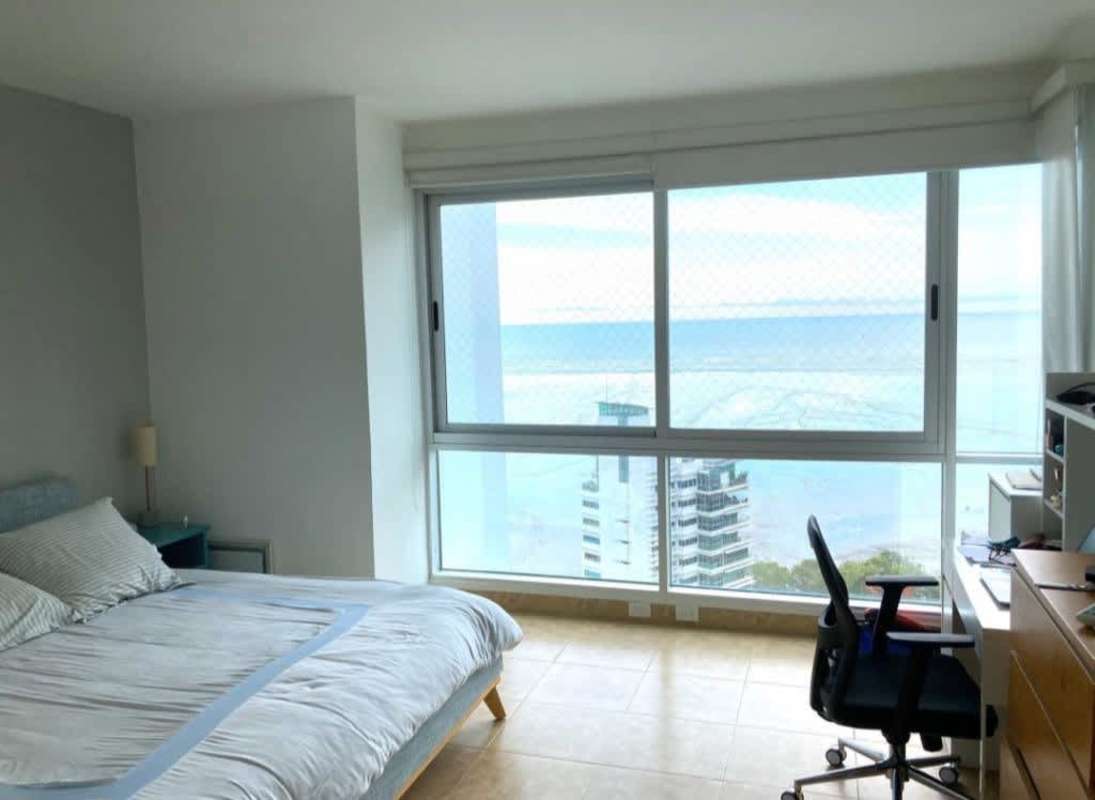 Bedroom with wide sea-facing windows offering Pacific Ocean views in PH Titanium Costa del Este Panama