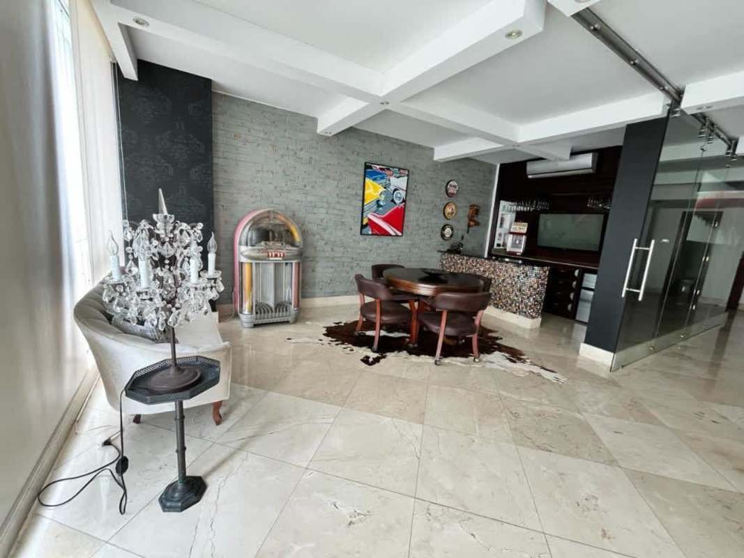 Entertainment lounge room with bar, jukebox, exposed brick, marble flooring at PH Peninsula Punta Paitilla