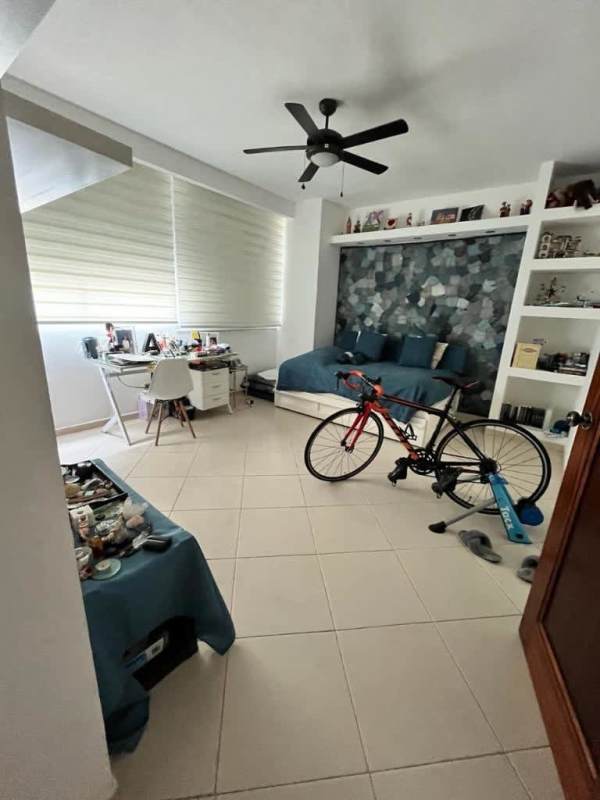 Modern bedroom with large window, blue accent wall, workspace in PH Peninsula Punta Paitilla